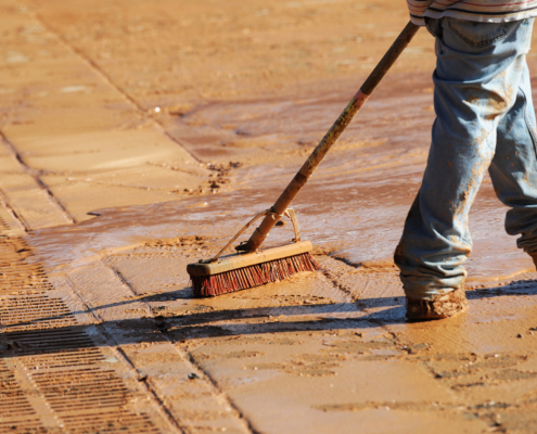 Side View, Worker Cleaning The Road In Construction Site